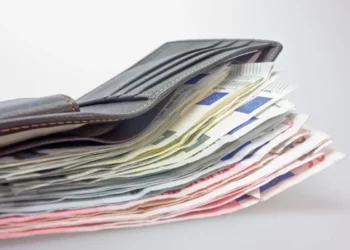 Portafoglio di pelle grigia aperto, con una pila di banconote da euro di vari tagli