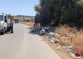 Rifiuti abbandonati sul ciglio di una strada provinciale, operatori al lavoro per la rimozione con un mezzo del Consorzio