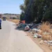 Rifiuti abbandonati sul ciglio di una strada provinciale, operatori al lavoro per la rimozione con un mezzo del Consorzio