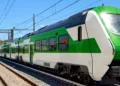 Treno regionale bianco e verde su binari elettrificati, immagine di repertorio per la linea Catania-Siracusa
