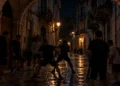 Rissa notturna tra ragazzi in un vicolo del centro storico, sotto un arco in pietra. Immagine generata con intelligenza artificiale.