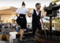 Pigiatura dell'uva a piedi nudi durante la Sagra della Vendemmia di Pedalino, con pubblico in festa sullo sfondo