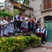 Gruppo folk in costume tradizionale siciliano su una scala di un antico edificio in pietra, per la sagra della vendemmia