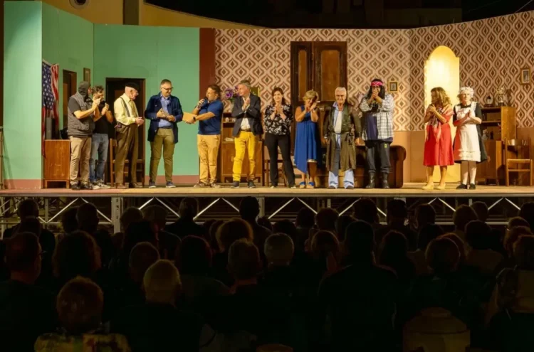 Attori in costume sul palco della Sagra della Vendemmia di Pedalino durante i saluti finali, pubblico in platea