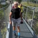 Salvatore Cavallaro cammina su un ponte sospeso in un bosco durante un'escursione in montagna