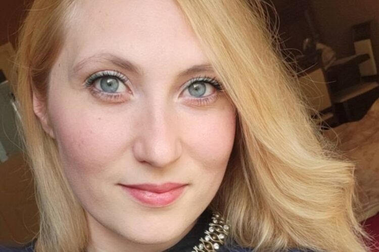 Samantha Pisani, corista con Il Volo, in primo piano: capelli biondi mossi, occhi azzurri e collana con pietre brillanti