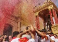 Il simulacro di San Giovanni Battista tra i fedeli, sommerso da coriandoli rossi e dorati davanti alla chiesa
