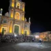 Chiesa di San Giovanni Battista illuminata a Monterosso Almo, pubblico e artista di strada con la ruota durante l'ArtFest