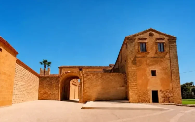 Ingresso in pietra e cortile del Santuario delle Milizie a Scicli, sotto cielo sereno