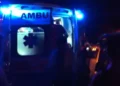 Ambulanza del 118 a porte aperte durante un intervento notturno di soccorso, persone intorno al mezzo