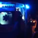 Ambulanza del 118 a porte aperte durante un intervento notturno di soccorso, persone intorno al mezzo