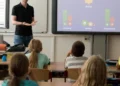 Aula scolastica con bambini e insegnante davanti a uno schermo interattivo