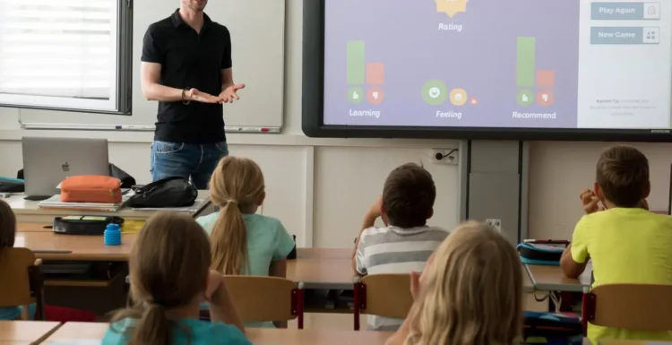Aula scolastica con bambini e insegnante davanti a uno schermo interattivo