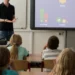 Aula scolastica con bambini e insegnante davanti a uno schermo interattivo
