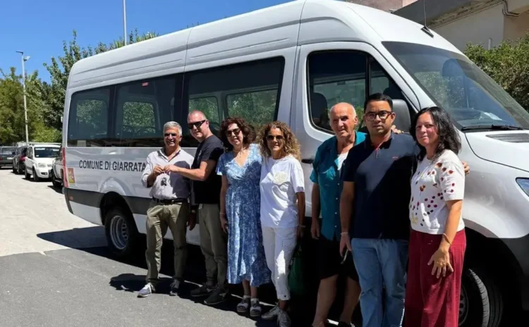 Rappresentanti del Comune di Giarratana davanti al nuovo scuolabus bianco durante la consegna delle chiavi.