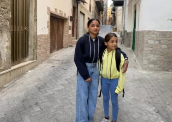Le due sorelle scomparse abbracciate in un vicolo: la maggiore con felpa blu, la minore con giacca gialla