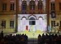 Spettacolo teatrale in piazza Municipio a Pozzallo, due attori sul palco illuminato davanti al pubblico, di sera