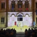 Spettacolo teatrale in piazza Municipio a Pozzallo, due attori sul palco illuminato davanti al pubblico, di sera