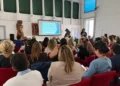 Pubblico sulle poltrone rosse della sala per l'incontro sulla storia del gospel a Modica, con la slide proiettata sullo schermo
