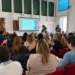 Pubblico sulle poltrone rosse della sala per l'incontro sulla storia del gospel a Modica, con la slide proiettata sullo schermo