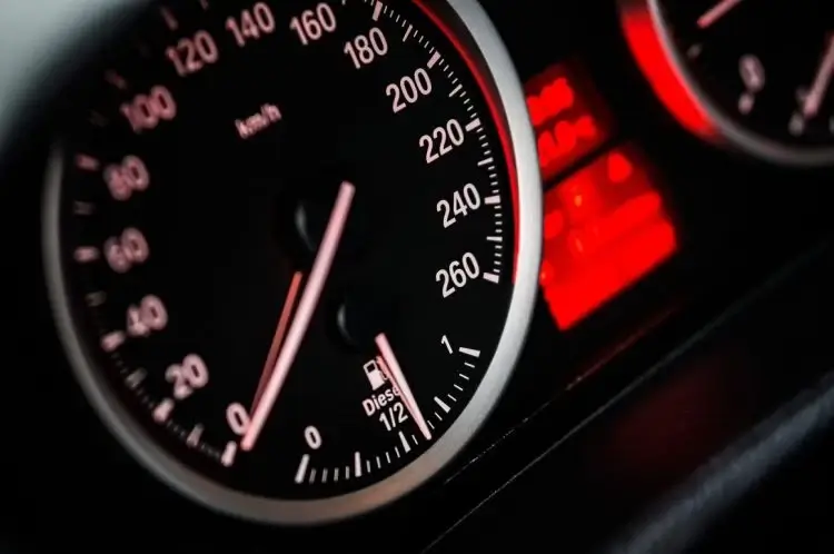 Cruscotto di un'auto diesel in penombra: tachimetro fino a 260 km/h con lancetta a zero, livello carburante a metà e spie rosse