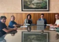 Cinque persone al tavolo della firma del contratto per i lavori stradali dell'aeroporto, la presidente al centro