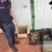 Carabiniere accanto a cassette e scatola piene di tartarughe sequestrate a Trecastagni, con una gabbia in primo piano