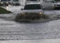 Auto attraversano una strada allagata durante forti temporali