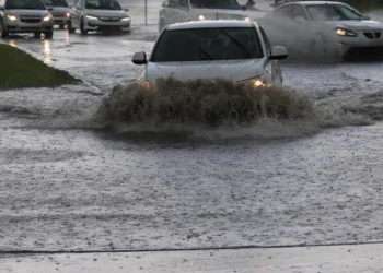 Auto attraversano una strada allagata durante forti temporali