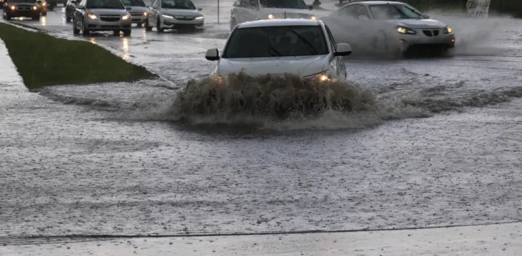 Auto attraversano una strada allagata durante forti temporali