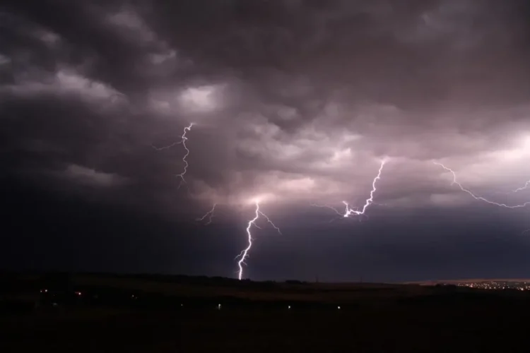 Temporali Sicilia con fulmini illuminano un cielo scuro sopra una zona rurale