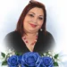 Ritratto di Teresa Di Giacomo, sorridente, con una composizione di rose blu simbolo del ricordo