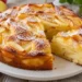 Torta di mele cremosa tagliata, con strati di mela e zucchero a velo. Immagine generata con intelligenza artificiale