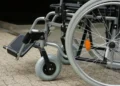 Dettaglio di una sedia a rotelle: ruote e pedana, simbolo del trasporto per persone con disabilità