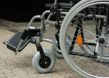 Dettaglio di una sedia a rotelle: ruote e pedana, simbolo del trasporto per persone con disabilità