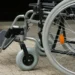 Dettaglio di una sedia a rotelle: ruote e pedana, simbolo del trasporto per persone con disabilità