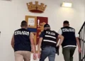 Agenti della Polizia di Stato accompagnano un fermato su una scala della Questura di Ragusa