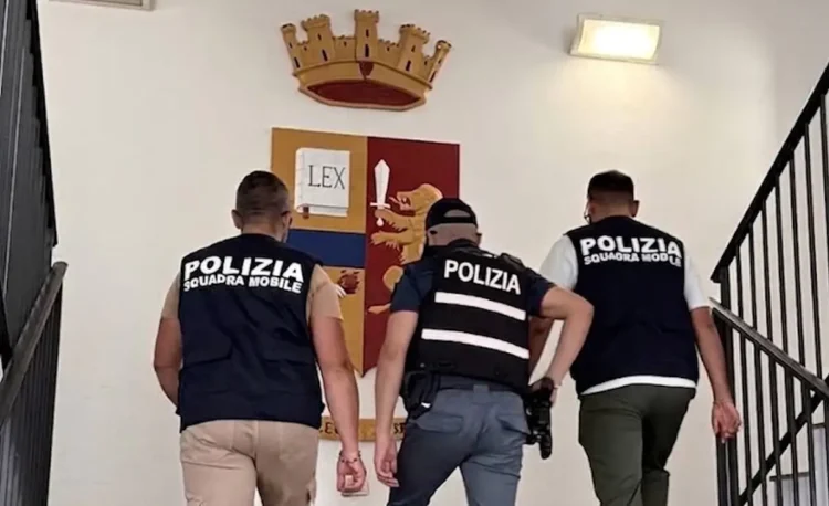 Agenti della Polizia di Stato accompagnano un fermato su una scala della Questura di Ragusa