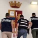 Agenti della Polizia di Stato accompagnano un fermato su una scala della Questura di Ragusa
