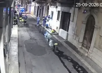 Vigili del fuoco e operatori in una strada di Comiso di notte durante l'intervento per un uomo agitato, da una telecamera