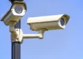 Due telecamere di videosorveglianza fissate su un palo, sullo sfondo cielo azzurro