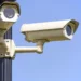 Due telecamere di videosorveglianza fissate su un palo, sullo sfondo cielo azzurro