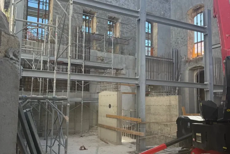Cantiere all'interno di Villa Moltisanti a Ragusa, con impalcature e travi in acciaio tra le mura storiche
