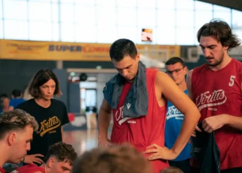 Giocatori della Virtus Ragusa in maglia rossa nello spogliatoio dopo un allenamento, con lo staff tecnico