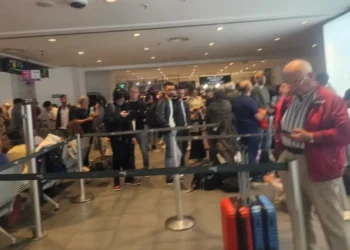 Passeggeri in fila tra le transenne nell'aeroporto di Catania con valigie, durante lo stop dei voli per la cenere dell'Etna