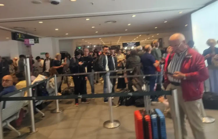 Passeggeri in fila tra le transenne nell'aeroporto di Catania con valigie, durante lo stop dei voli per la cenere dell'Etna