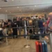 Passeggeri in fila tra le transenne nell'aeroporto di Catania con valigie, durante lo stop dei voli per la cenere dell'Etna