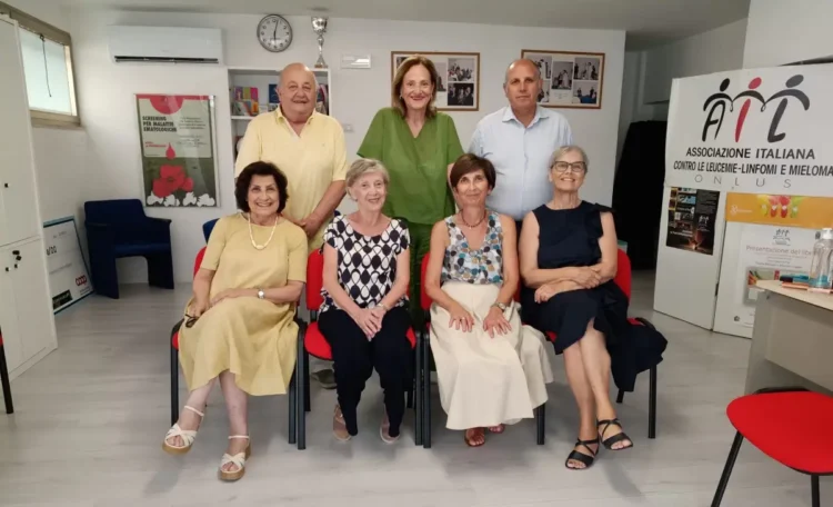 Otto persone in posa in una stanza di AIL Ragusa, accanto allo striscione dell’Associazione contro leucemie, linfomi e mieloma