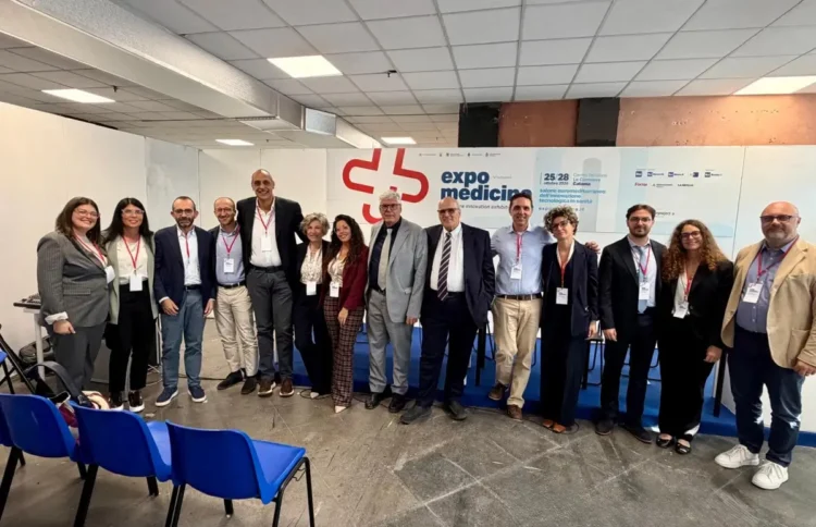 Delegazione dell’ASP di Ragusa in posa davanti al pannello di ExpoMedicina 2026, alle Ciminiere di Catania