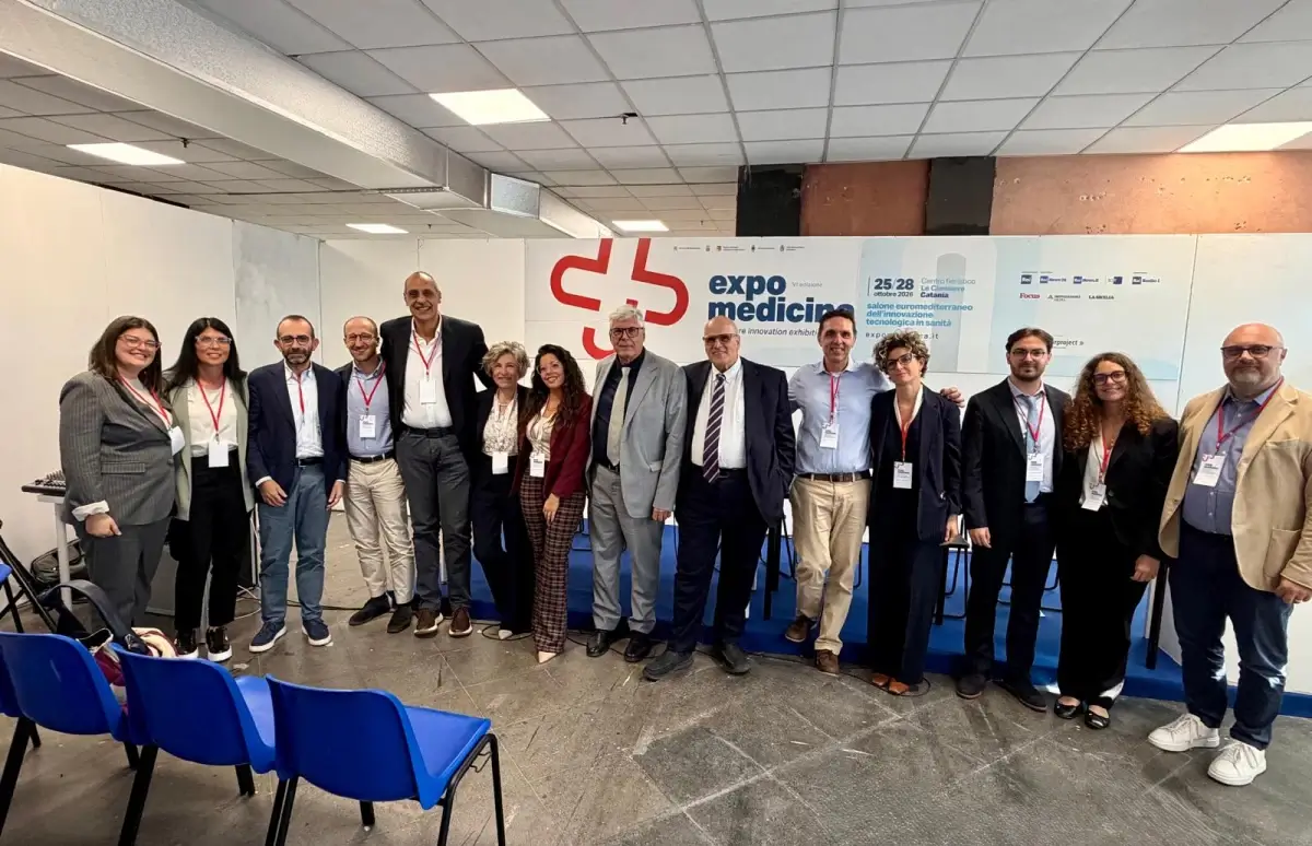 Delegazione dell’ASP di Ragusa in posa davanti al pannello di ExpoMedicina 2026, alle Ciminiere di Catania